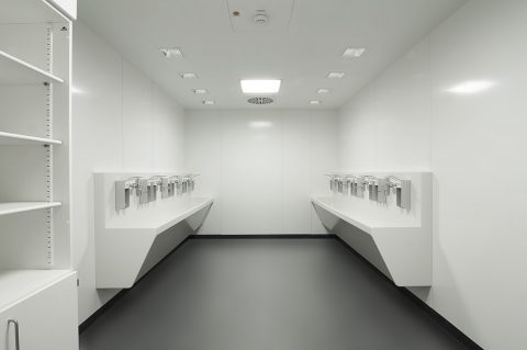 Extremely clean work room with pristine white hygienic walls and surfaces